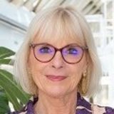Irene Ausserlechner ©Universitätsklinikum AKH Wien, Mayer-Egerer Porträt einer älteren Frau mit blondem Bob-Haarschnitt und Brille, vor einem hellen, modernen Hintergrund mit Pflanze. ©Universitätsklinikum AKH Wien, Mayer-Egerer